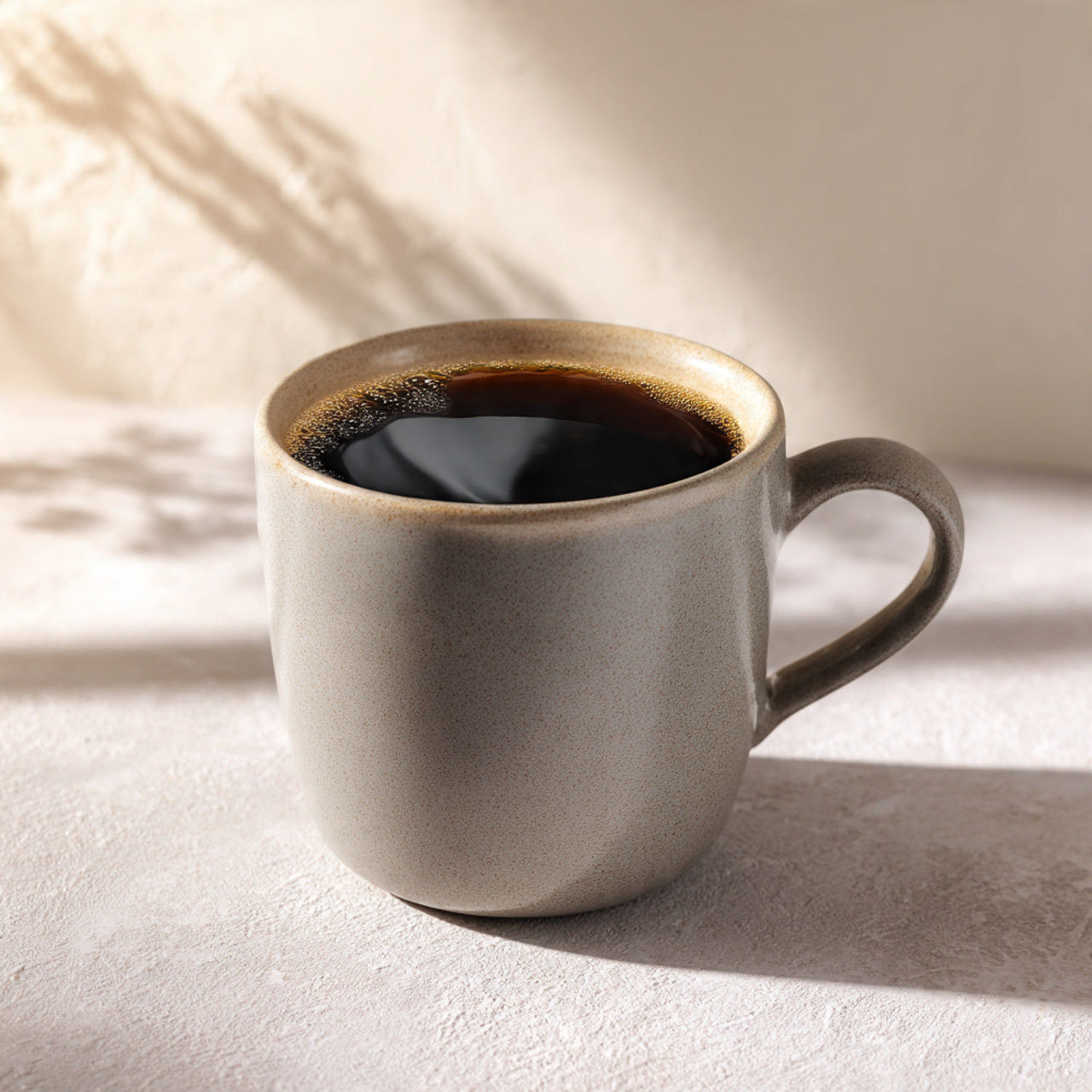 Ceramic mug with gourmet donut shop coffee on a light surface with soft shadows