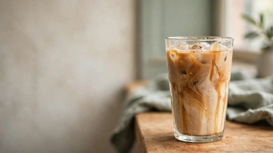 Homemade caramel iced latte in a clear glass with ice, creamy coffee swirls, caramel drizzle