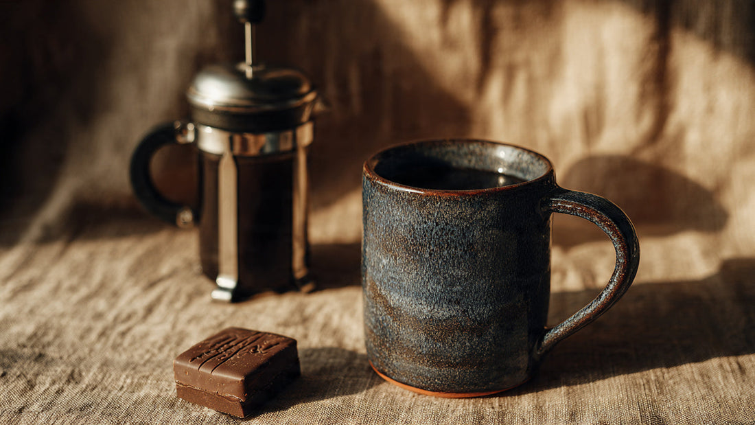 Italian Roast coffee in dark mug on textured table.