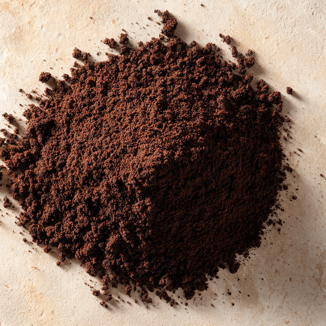 Close-up of ground coffee on a textured surface