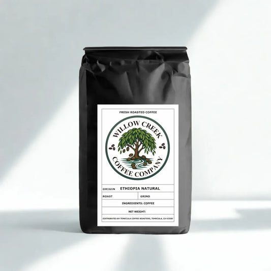 Black coffee bag with Willow Creek Coffee Company label on a light gray background