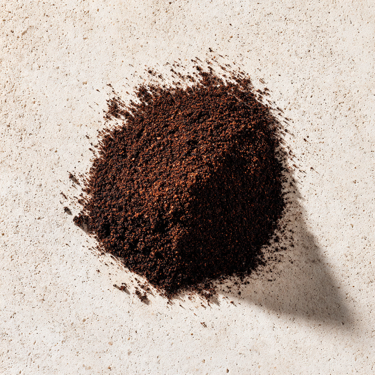 Coarse ground peru coffee on a light beige surface