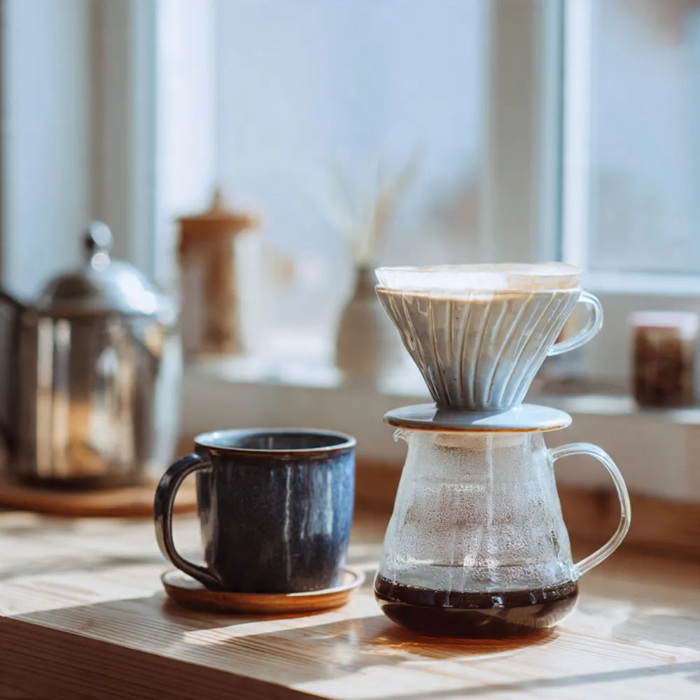 Sumatra coffee brewing setup with a pour-over coffee maker and a cup on a wooden surface.